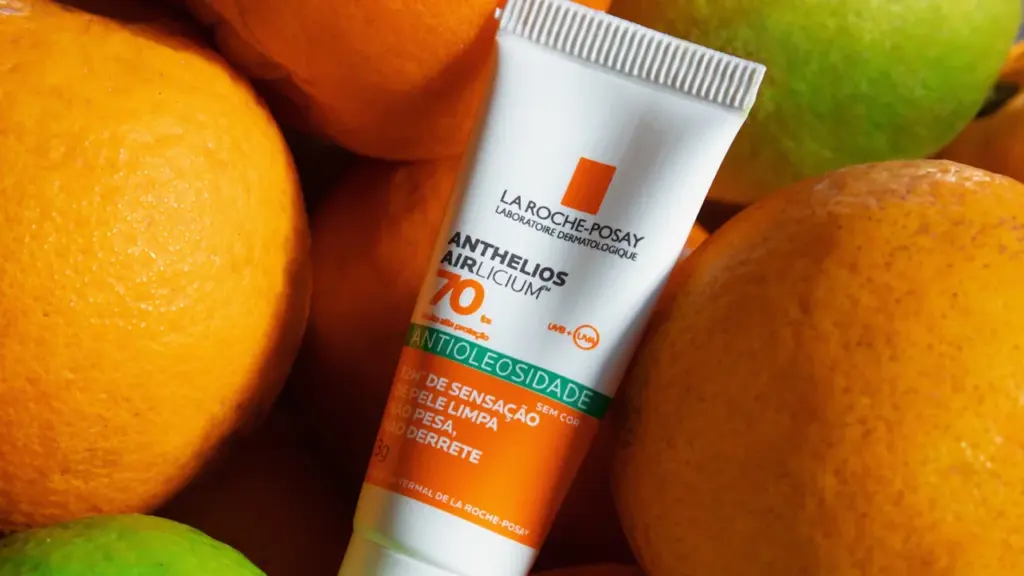 Tube de crème solaire sur fond d'agrumes évoquant la chaleur estivale intense.