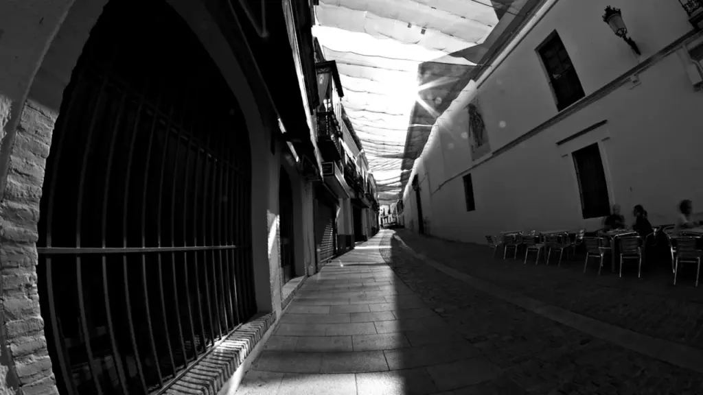 Une ruelle commerçante ombragée par des toiles pour protéger de la forte chaleur estivale.