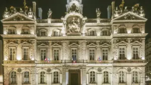 Vue nocturne majestueuse de l'Hôtel de Ville de Lyon, symbole de l'administration municipale.