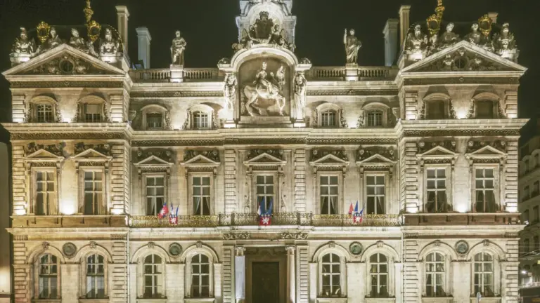Vue nocturne majestueuse de l'Hôtel de Ville de Lyon, symbole de l'administration municipale.