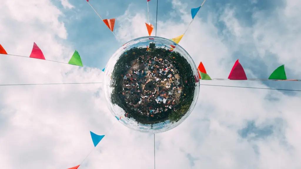 Une boule à facettes reflétant la foule sous des drapeaux colorés à Nanterre.