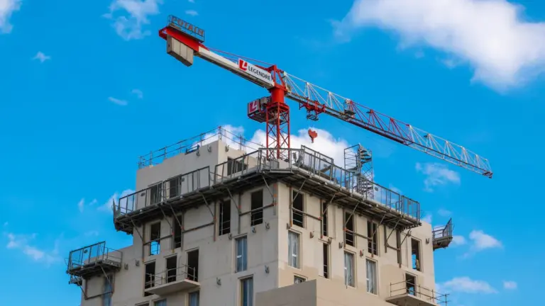 Une grue de chantier domine un immeuble en construction moderne à Nantes.