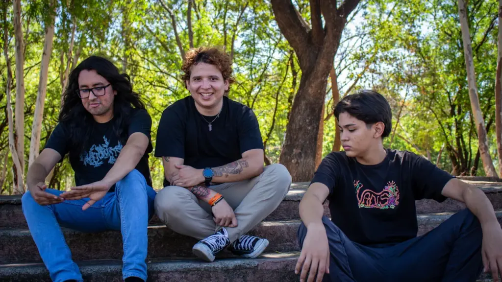 Trois adolescents assis sur des marches en extérieur, profitant d'une journée ensoleillée.