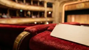 Gros plan sur un fauteuil de théâtre en velours rouge avec une carte blanche.