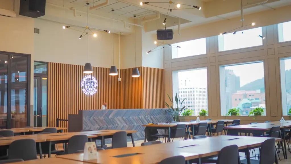 Ambiance studieuse et épurée d'une salle à manger ou espace de coworking moderne.