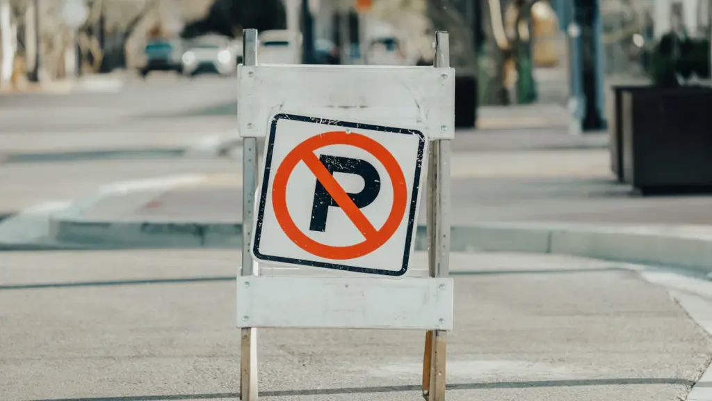 Un panneau de signalisation indiquant une interdiction de stationner dans une rue urbaine.