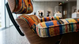 Gros plan sur un fauteuil en bois avec un revêtement en tissu multicolore texturé.