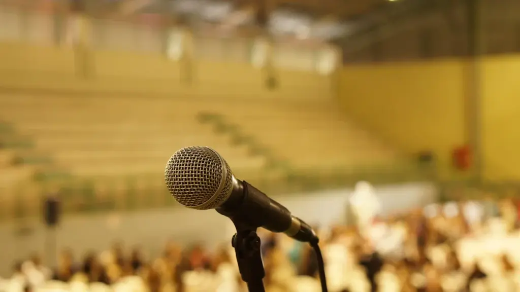 Microphone sur pied devant les gradins vides d'une salle de réunion municipale.
