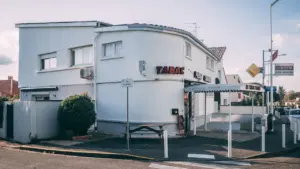 Bâtiment blanc typique en France avec une enseigne Tabac sur la façade extérieure.