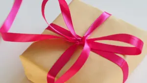 Un paquet cadeau en papier kraft avec un ruban rose fuchsia élégant.