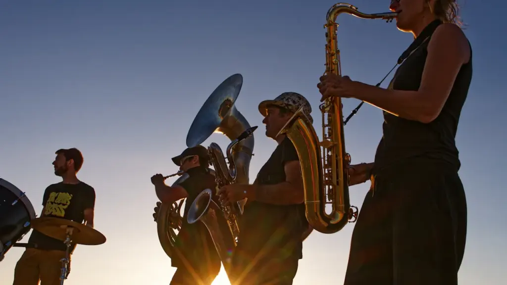 Un groupe de musiciens jouant des cuivres au coucher du soleil en France.