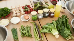 Ingrédients frais et légumes de saison disposés sur une table en bois pour cuisiner.