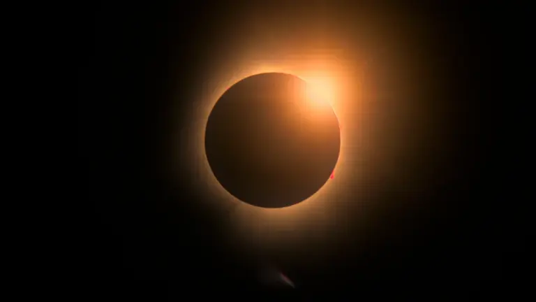 Une éclipse solaire totale avec un cercle sombre entouré d'un brillant anneau de lumière.
