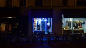 Façade de boutique illuminée à la tombée de la nuit dans une rue française.