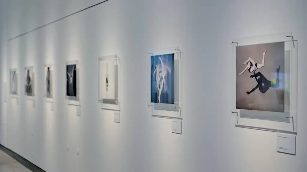 Une galerie d'art contemporaine moderne avec des cadres suspendus sur un mur blanc.