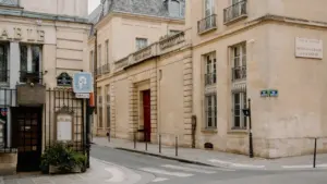 Une rue parisienne paisible et architecturale avec un passage piéton au premier plan.