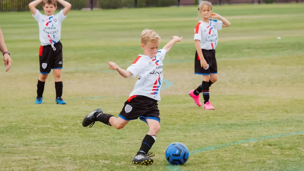 Des jeunes enfants pratiquant une activité sportive de plein air sur un terrain.