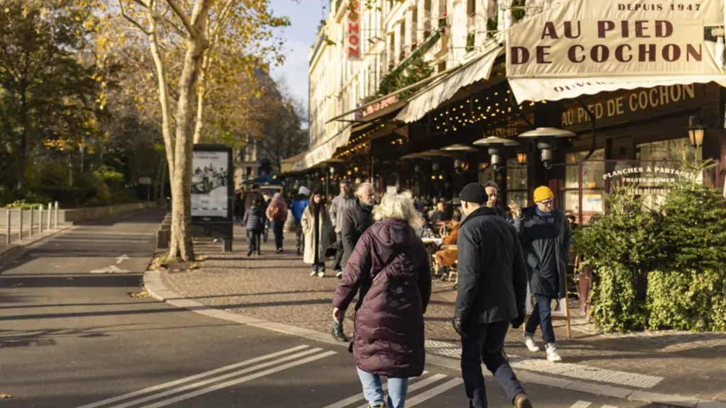 Des piétons traversent une rue près du restaurant parisien emblématique Au Pied de Cochon.