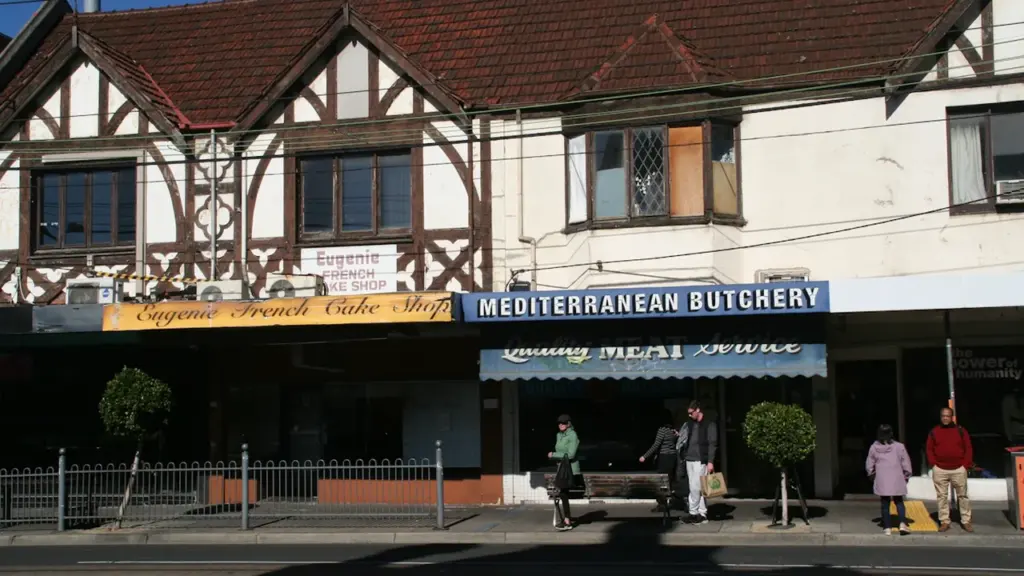 Bâtiments de style Tudor avec des commerces au niveau de la rue à Courbevoie.